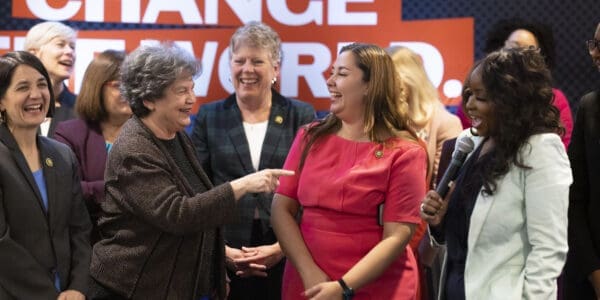 Image of a group of EMILYs List candidates laughing and smiling together on stage.