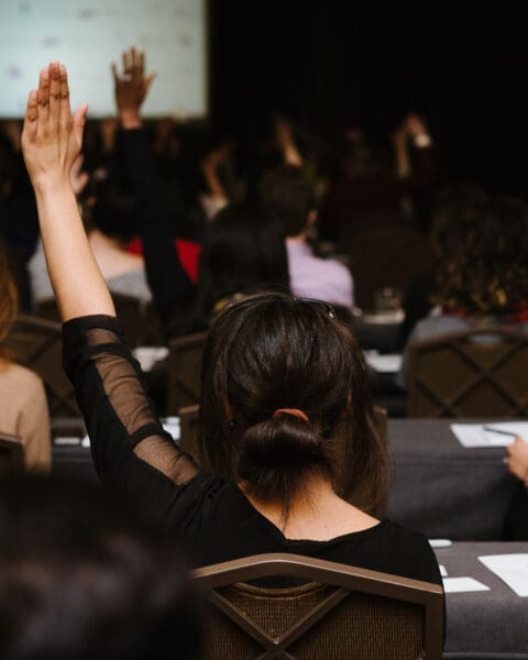Image of EMILYs List members raising their hands during a training.